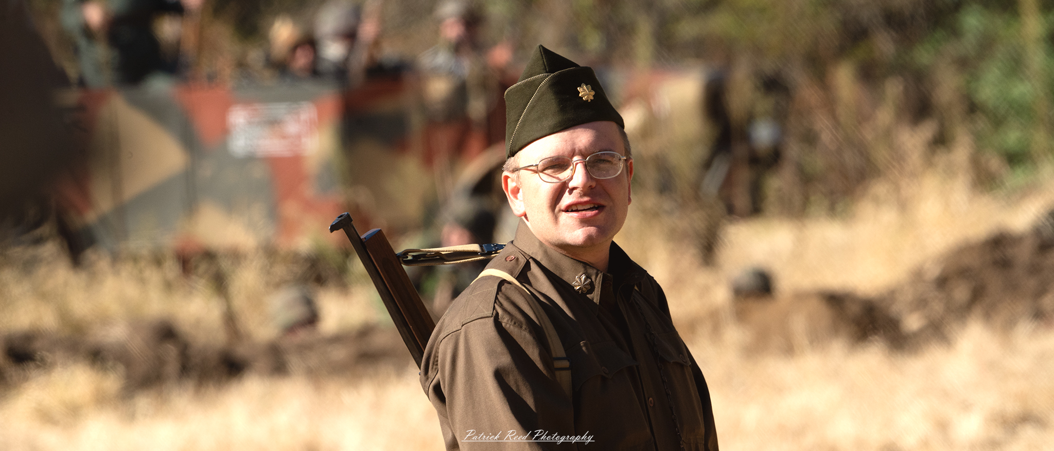 "Portrait of a World War II major in full uniform, standing proudly with a serious expression. The major's uniform, adorned with insignia and medals, reflects his rank and achievements. He is positioned against a backdrop that evokes the era, possibly featuring military equipment or a battlefield setting. The lighting emphasizes the details of his uniform and the determination in his gaze, capturing the essence of leadership and sacrifice during the war. This image highlights the pivotal role of officers in military operations and the weight of responsibility they carried during one of history's most significant conflicts."